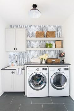 a washer and dryer in a laundry room with blue tiles on the wall