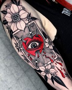 a woman's arm with an eye and flowers on it