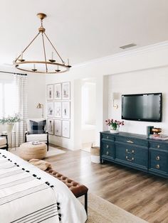 a bedroom with a bed, dresser and tv in it's centerpieces