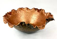 a metal bowl sitting on top of a white table