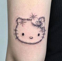 a hello kitty tattoo with barbed wire on the arm and behind it is a cat's head