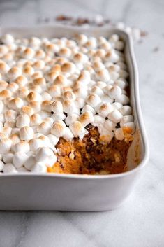 a casserole dish with marshmallows in it on a marble surface