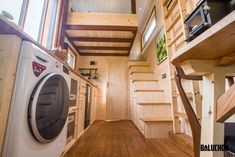 a washer and dryer in a small room with wood flooring on the walls