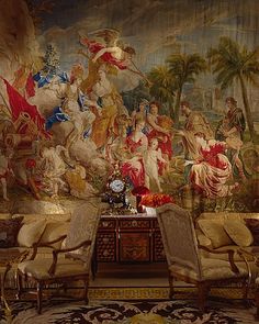 a room with a large painting on the wall next to two chairs and a table