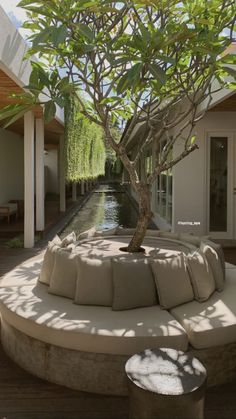 an outdoor seating area with a tree in the middle