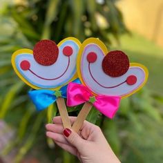 two handmade lollipops with bows are shown in front of a potted plant