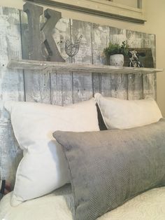 a bed with white pillows and wooden headboard