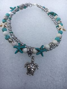 This pretty double strand beach anklet is made with a silver plated metal turtle charm, turquoise and white starfish, turquoise and white howlite beads, silver Tibetan beads, and silver glass beads. Beach anklet measures 10 inches and closes with a silver lobster clasp. Not your size? No problem! Just message me and Ill be happy to make your size for you Starfish Anklets, Ankle Bracelets Diy, Turtle Jewelry, Ankle Jewelry, Anklets Boho, Beach Anklets, Turquoise Jewelry Native American, Women Anklets, Ocean Jewelry