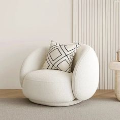 a white chair sitting on top of a wooden floor next to a table and lamp