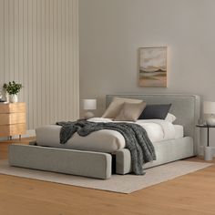 a large bed sitting on top of a hard wood floor next to a white wall