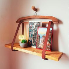 a wooden shelf with pictures and a potted plant on it