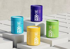 three cans of moxe sitting on top of blocks