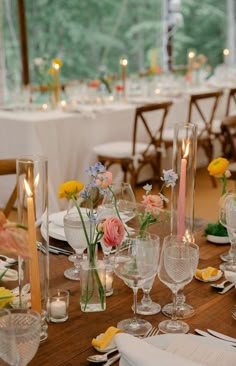 the table is set with flowers, candles and place settings for an elegant dinner party