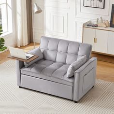 a living room with a gray couch and white rug