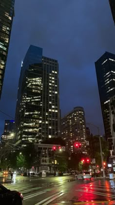 a city street at night with traffic lights and skyscrapers