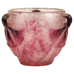 a pink vase sitting on top of a white table