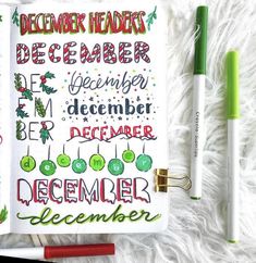 an open christmas planner next to two pens and markers on a white furnishing