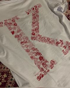 a t - shirt that has been made to look like the letter k with flowers on it