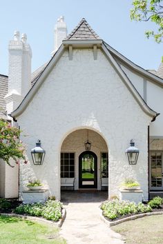 a white house with two lamps on the front door