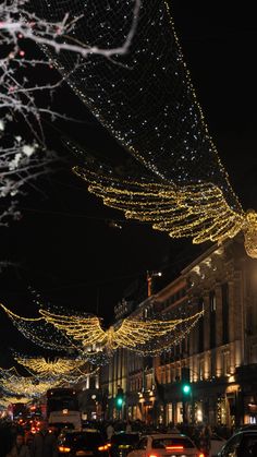 cars are driving down the street covered in christmas lights