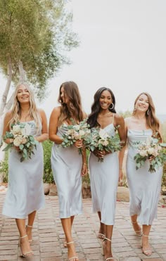 four bridesmaids in white dresses walking together