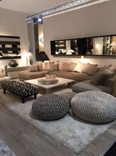 a living room filled with lots of couches and pillows on top of a wooden floor