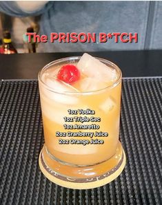 the prison b tch cocktail is served in a tall glass with a cherry on top