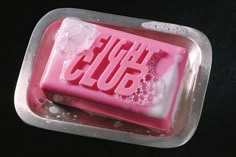 a pink soap with the word glue on it in a plastic container filled with water