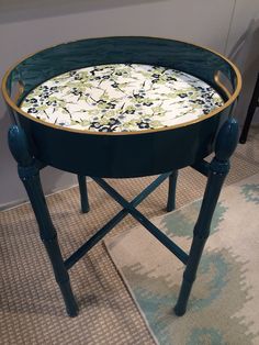 a green chair with a white and blue flowered seat