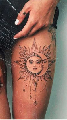 a woman's thigh with a sun and moon tattoo on it