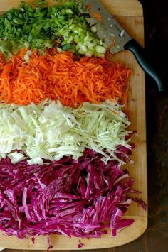 a cutting board topped with different types of veggies on top of each other