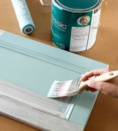 a person is painting the inside of a door with blue paint and a white brush