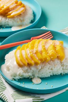 two blue plates topped with rice covered in mango sauce and sliced pineapple on top