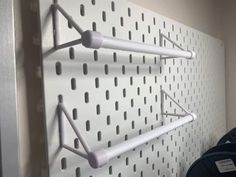 three white pegboards mounted to the side of a wall