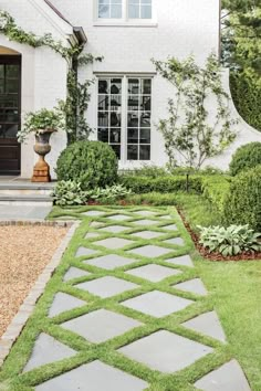 a white house with green grass and stone walkway leading up to the front door area