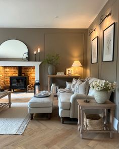 a living room filled with furniture and a fire place under a mirror on the wall