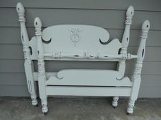 a white wooden bed frame sitting in front of a building