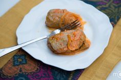 two dumplings on a white plate with a fork