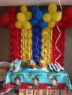 a table topped with lots of balloons and cake