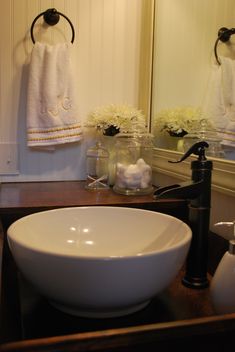 a white bowl sink sitting on top of a wooden counter