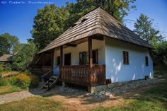 a small white house with a brown roof