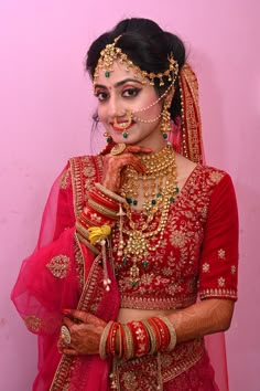 a woman dressed in red and gold poses for the camera