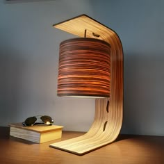 a lamp that is on top of a wooden table next to a pair of glasses