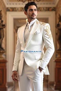 =>UNIQUE CREATION - PLEASE RESPECT COPYRIGHT<= All images and content on this site are exclusively crafted and owned by Paridhanin. Unauthorized copying, sharing, or reproduction is prohibited and will be subject to legal action. This stunning white suit features luxurious gold embroidery on the shoulders and cuffs, providing an elegant and refined look. Made from premium fabric, it offers a tailored fit that exudes sophistication. Perfect for grooms seeking a classic yet contemporary style for weddings or formal events, ensuring a memorable appearance. The price includes Jacket and pant only. Other accessories if you want like shirt , tie and pocket square will be available on extra cost. For this message us in personalisation box. The suit is meticulously crafted from a luxurious  polyes White And Gold Tuxedo Groom Suits, Ivory Wedding Tuxedo For Men, Off White Wedding Suit For Men, White Suit With Gold Accents, White And Gold Suit Men, Fitted White Unstitched Suit With Naqshi, Designer White Wedding Suit, Elegant Gold Unstitched Suit For Wedding, Elegant Gold Unstitched Wedding Suit