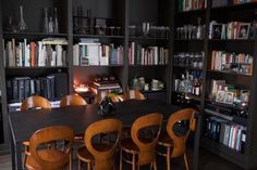 a dining room table surrounded by bookshelves and chairs