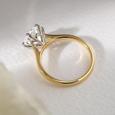 a diamond ring sitting on top of a white sheet