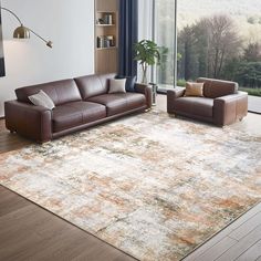 a living room with couches, chairs and a large rug in front of a window