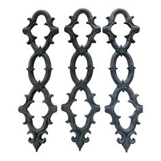 three black wrought iron designs on a white background