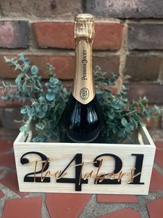 a bottle of champagne sitting in a wooden crate with the number 24 on it's side