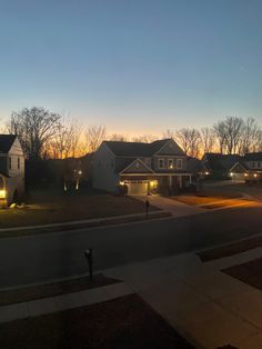 the sun is setting over some houses and trees